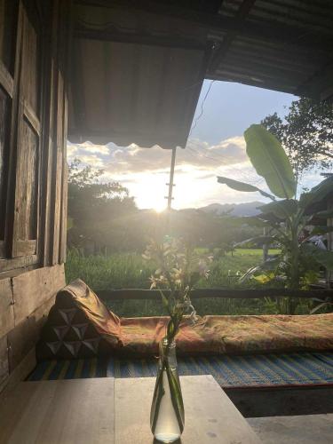 un vase assis sur une table devant une fenêtre dans l'établissement Banana garden, à Pai