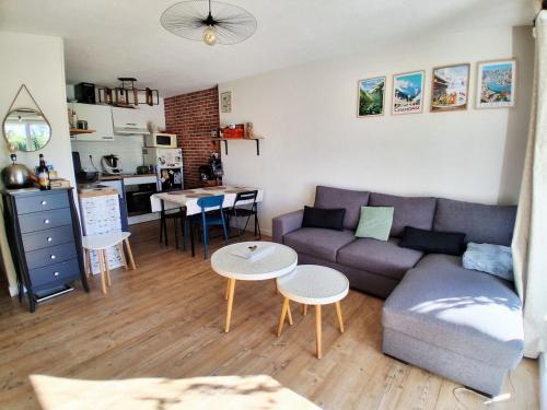 una sala de estar con un sofá y una mesa en CosyMontBlanc apartment with pool, en Nangy