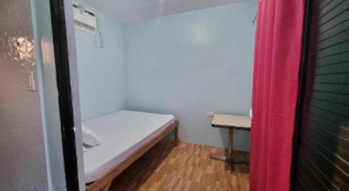 a small room with a bed and a table at Yemaya de Laiya powered by Cocotel in Batangas City