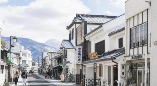 a city street with buildings and people walking down the street at Premier Hotel Cabin Matsumoto in Matsumoto