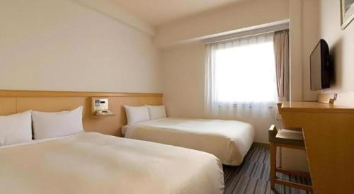 a hotel room with two beds and a window at Premier Hotel Cabin Matsumoto in Matsumoto