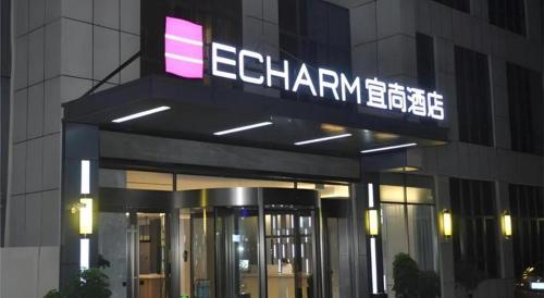 a building with a sign on top of it at Echarm Hotel Xiangyang Erqi in Xiangyang