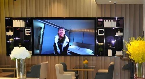 a television on a wall with a man on it at Echarm Hotel Xiangyang Erqi in Xiangyang
