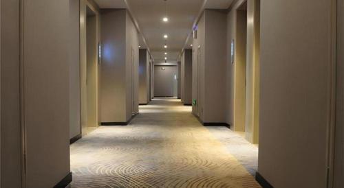 a hallway of a building with a long corridor at Echarm Hotel Xiangyang Erqi in Xiangyang
