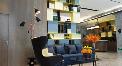 a living room with a blue couch and a table at Echarm Hotel Xiangyang Erqi in Xiangyang