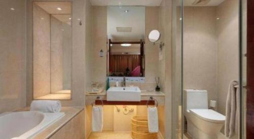 a bathroom with a tub and a sink and a toilet at Ramada by Wyndham Zibo in Zibo