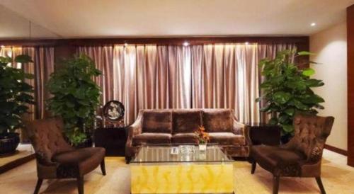 a living room with a couch and two chairs at Ramada by Wyndham Zibo in Zibo