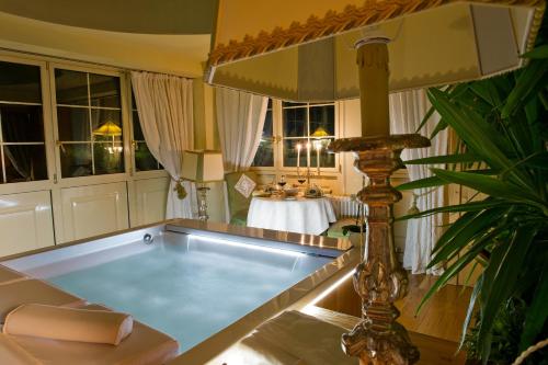 a bath tub in a room with a table at Villa Orso Grigio in Ronzone