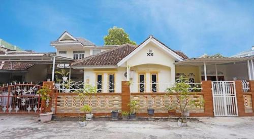 a house with a wooden fence in front of it at Hotel O Wisma Pinggir in Tanjung Pinang 