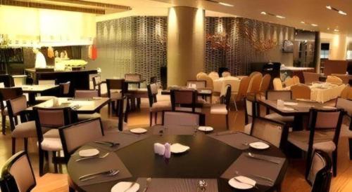 a dining room with tables and chairs in a restaurant at Ramada by Wyndham Xi'an Bell Tower in Xi'an