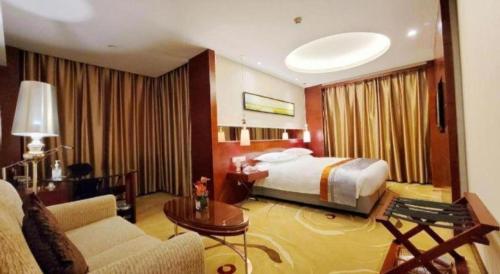 a large hotel room with a bed and a couch at Ramada by Wyndham Zibo in Zibo