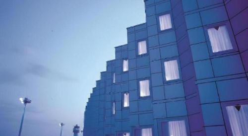 a blue building with windows on the side of it at Air Terminal Hotel in Chitose