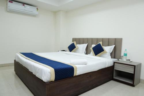 Un dormitorio con una cama grande con almohadas azules y blancas. en Hotel Gopala, en Indore