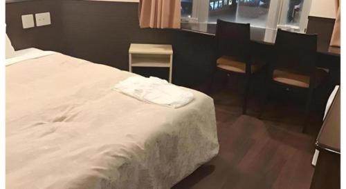 a bedroom with a bed and a table and chairs at Hotel Gran View Okinawa in Naha