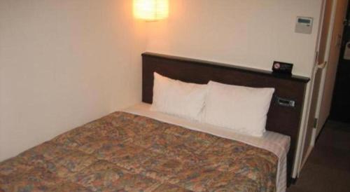 a hotel room with a bed with white pillows at Hotel Gran View Okinawa in Naha