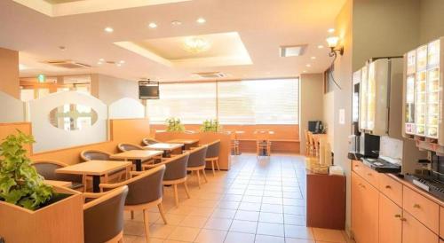 a restaurant with tables and chairs in a cafeteria at Smile Hotel Nishiakashi in Kobe