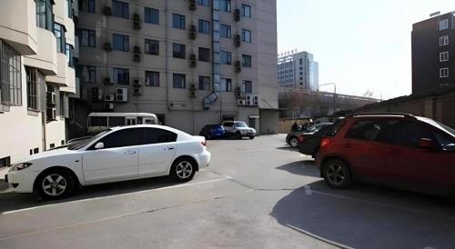 two cars parked in a parking lot next to a building at JinJiang Inn Nanjing The Confucius Temple Zhonghuamen Metro Station in Nanjing