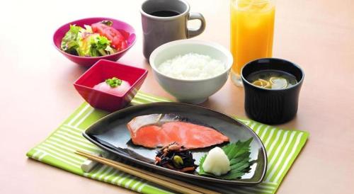 a table with a plate of food and bowls of food at KEIKYU EX INN Keikyu Kawasaki-Station in Kawasaki