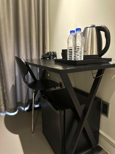 a table with two bottles of water and a tea kettle at Hotel Biz Suwon in Suwŏn-yŏk