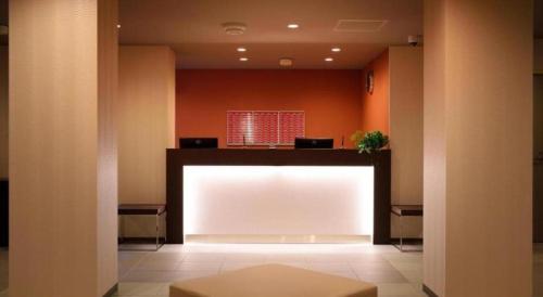 a large white screen in a room with orange walls at La'gent Inn Kesennuma in Higashi-hachimammae