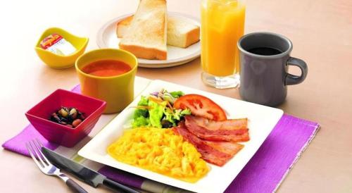 a plate of breakfast food with eggs bacon and toast at KEIKYU EX INN Keikyu Kawasaki-Station in Kawasaki