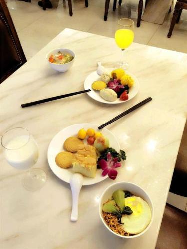 a table with plates of food and glasses of milk at GreenTree Alliance Anhui Hefei South Passenger Station South High Speed Railway Station Hotel in Hefei