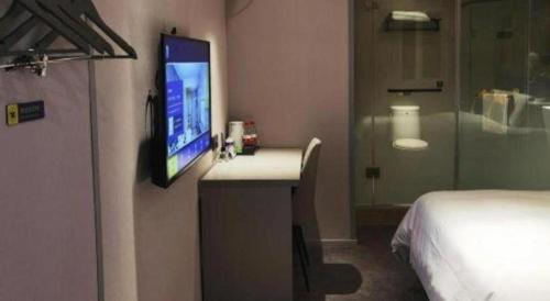 a hotel room with a tv on a wall at 7 Days Inn Nanjing Xinjiekou Changfu Street Metro Station in Nanjing