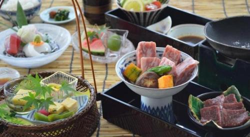 a table topped with bowls of different types of food at Hotel Harvest Nankitanabe in Tanabe