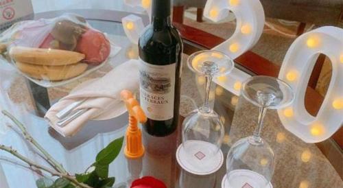 a table with two bottles of wine and two glasses at New Century Grand Hotel Xi'an Xizang Building in Xi'an