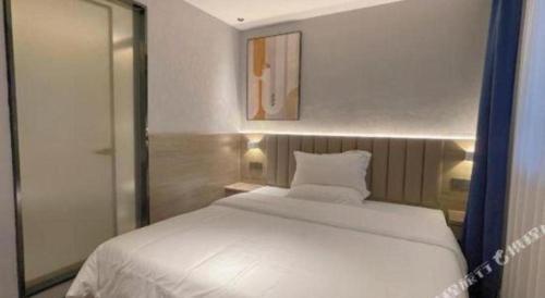 a bedroom with a white bed and a mirror at 7 Days Inn Deyang Zhongjiang Kuishan Park in Deyang
