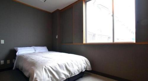 a bedroom with a bed with a large window at Hamakan Hotel in Unzen