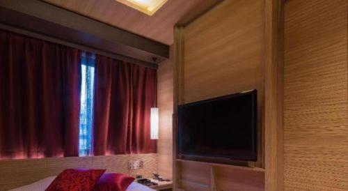 a bedroom with a flat screen tv and a bed at Hotel Ann Tsukiji in Tokyo