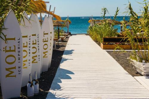 a path leading to a beach with surfboards on the sand at Kampanario Luxury Two-Bedroom Villa with Private Jacuzzi in Megalokhori