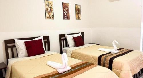 a room with two beds with white rabbits on them at Rueangrat Hotel in Ranong