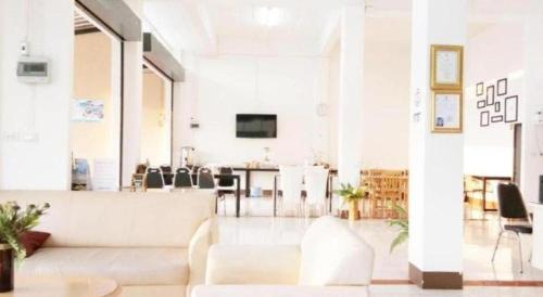 a living room with a white couch and a table at Rueangrat Hotel in Ranong