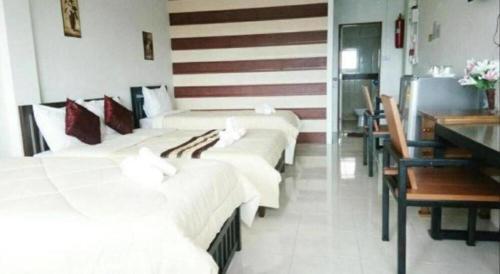 a hotel room with four beds and a desk at Rueangrat Hotel in Ranong