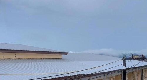 a train traveling past a building with snow on the roof at Rueangrat Hotel in Ranong
