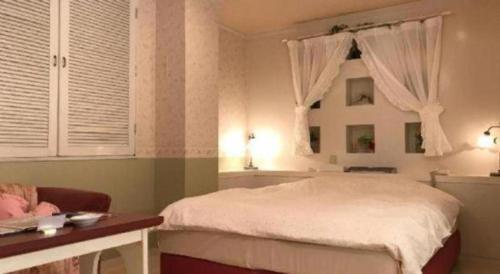 a bedroom with a white bed and a window at Tabist Hotel Please Kobe in Kobe