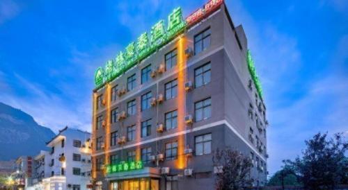 a building with green lights on the side of it at GreenTree Inn Huayin Huashan Town Huashan Scenicspot Express Hotel in Huayin
