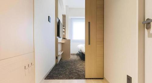 a hallway with a door leading to a bedroom at Hotel Yaenomidori Tokyo in Tokyo
