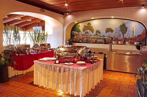 a restaurant with a table with food on it at Hotel Fortin Plaza in Oaxaca City