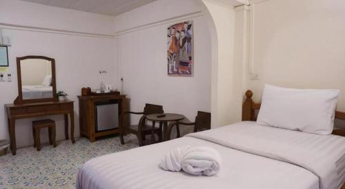 a bedroom with a bed with a towel on it at Nan Lanna Hotel in Nan