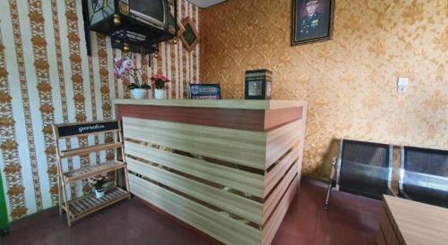 a bar with a wooden counter in a room at Hotel O Losmen Bunda Arema in Bangko