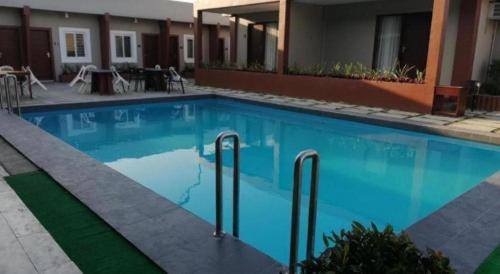 a large blue swimming pool next to a building at Sabine's Place in Masbate
