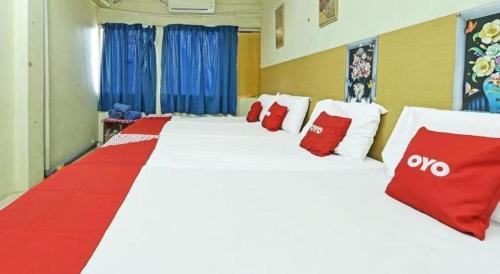 a room with a large bed with red and white pillows at SPOT ON 90625 Super Green Grass Hotel in Yong Peng
