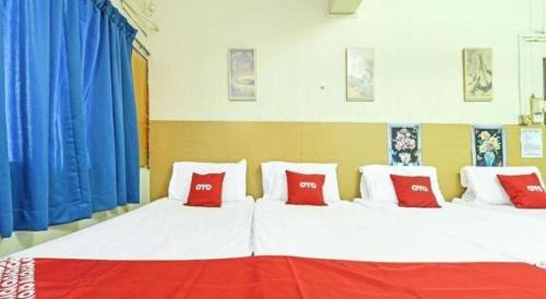 a large bed with red and white pillows on it at SPOT ON 90625 Super Green Grass Hotel in Yong Peng