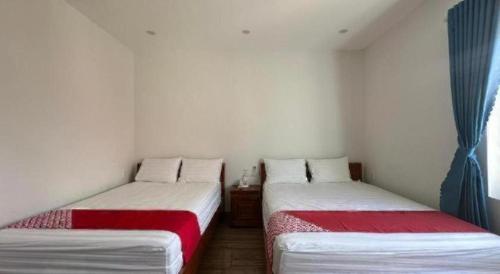 two twin beds in a small room with a window at Motel Phuong Linh in Da Nang