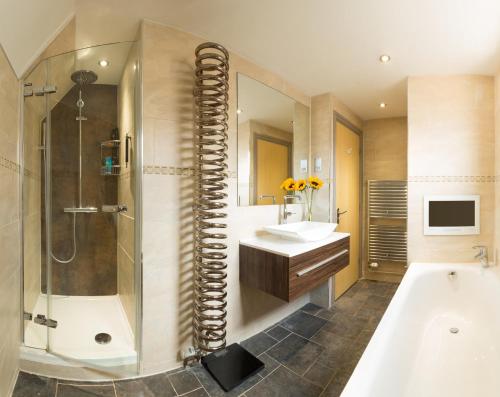 y baño con bañera, lavamanos y ducha. en Cherwell Gates 4 Bed Luxury Oxford Apartment for 8 with Roof terrace, en Oxford