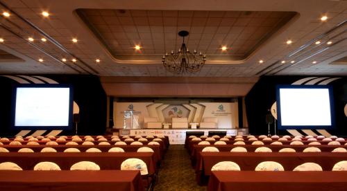 a room with rows of chairs and two screens at Hotel Fortin Plaza in Oaxaca City
