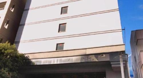 a white building with windows on the side of it at Hotel Route Inn Kitamatsudo Ekimae in Kashiwa